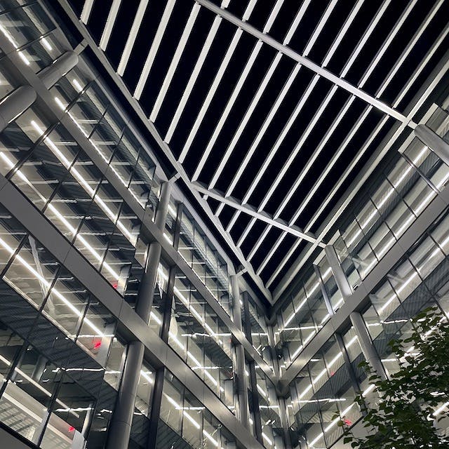 Corner of the Principal 750 Park building where several floors of glass-lined hallways intersect, creating dozens of brilliant, white reflections