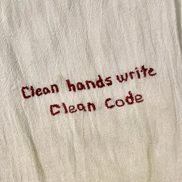 Embroidered hand towel that reads, 'Clean hands wrtie clean code'
