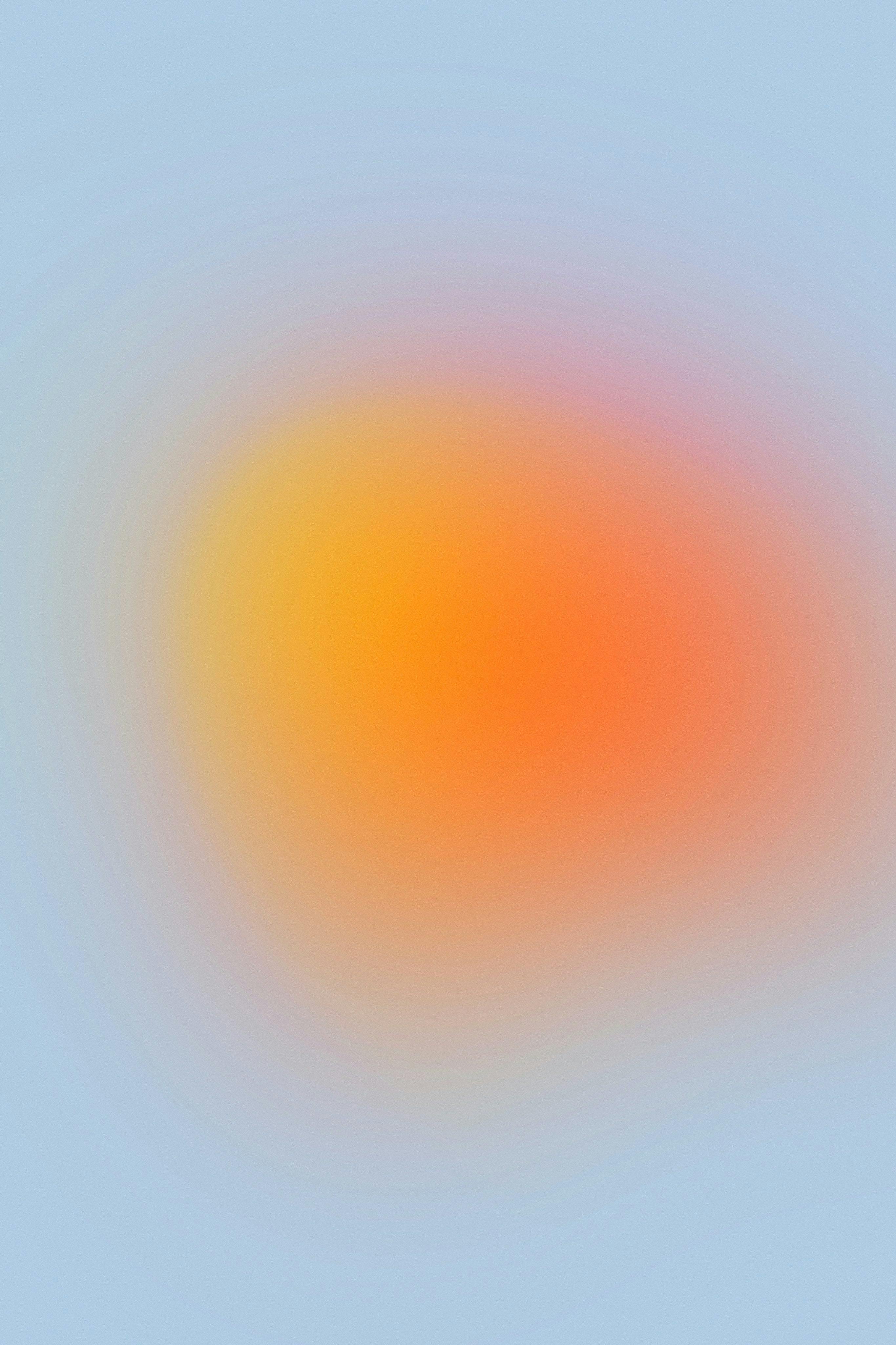 circular yellow-orange blurred radial gradient with pale blue background